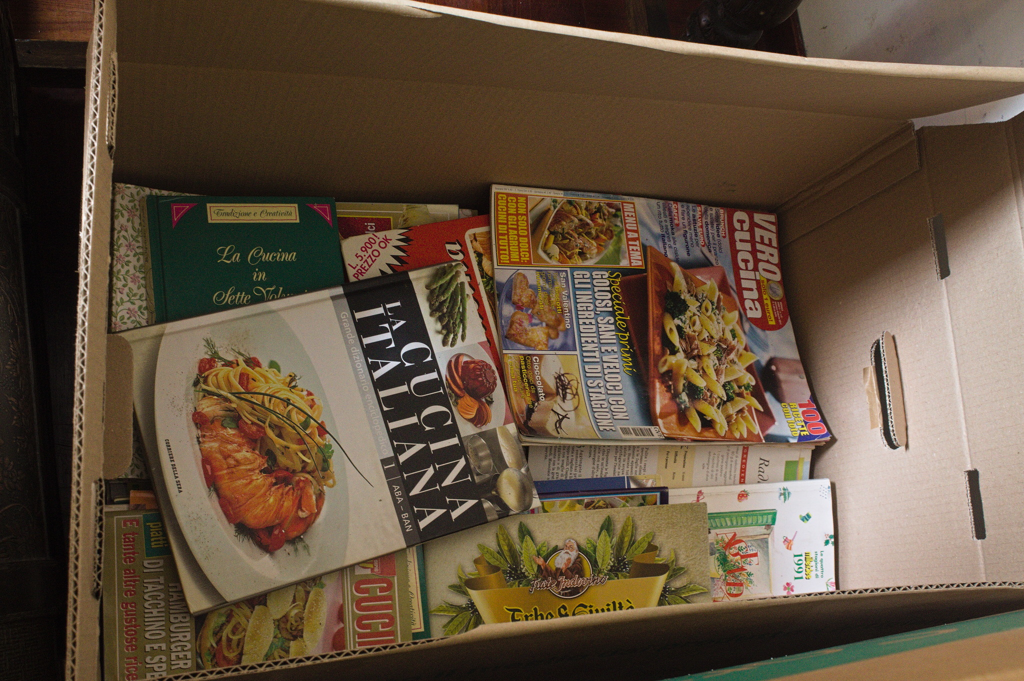 uno scatolone circa 60 cm × 40 cm × 25 cm contenente libri e riviste