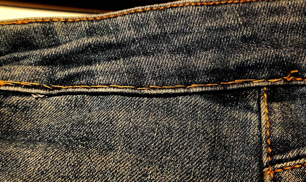 foto di una cucitura fatta a mano su un paio di jeans