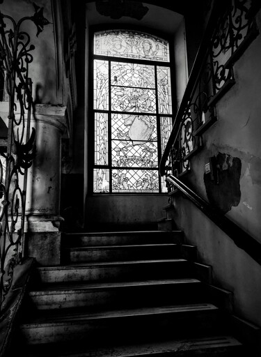 staircase going upwards, at landing latge stained glass window