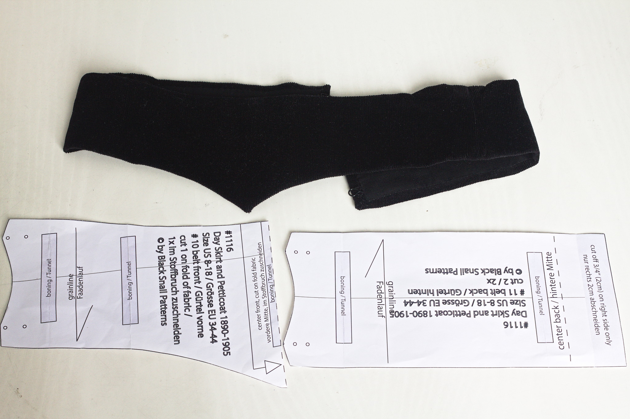 Una cintura di velluto nero, foderata di cotone nero; sui fianchi è alta circa 6 cm, che diventano 9 nel centro davanti. Nella foto si vede anche il cartamodello con cui è stata realizzata